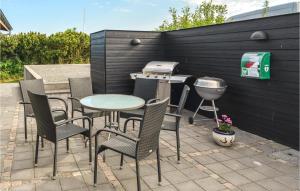 eine Terrasse mit einem Tisch, Stühlen und einem Grill in der Unterkunft Holiday Home Knebel 3 in Knebel
