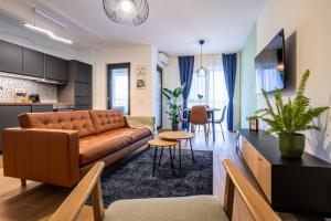 a living room with a couch and a table at The Evergreen Apt with Parking & Netflix - Romexpo, Piața Presei, Expoziției, Herăstrău in Bucharest