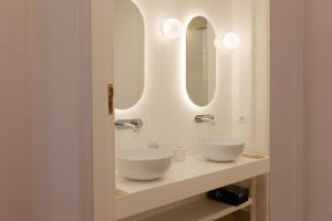 a bathroom with two sinks and a mirror at Antica Dimora sul Mare - Elegant Central Apartments - Molfetta in Molfetta