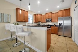 a kitchen with wooden cabinets and stainless steel appliances at Embrace Disney Magic at Our Luxe 6-BR Villa in ChampionsGate! in Davenport
