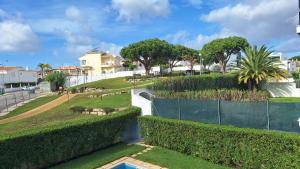 - Vistas a un parque con árboles y una valla en Apartamento Olhos do Mar, en Olhos de Água