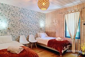 a bedroom with two beds and a window at La Montagne in Chambon-sur-Lac