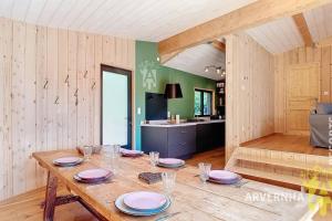 a dining room with a table and a kitchen at La Montagne in Chambon-sur-Lac