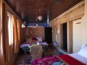 pokój z dwoma łóżkami, stołem i krzesłami w obiekcie Hotel Desert w mieście Jaisalmer