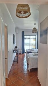 1 dormitorio con 2 camas y suelo de baldosa en Apartamento Olhos do Mar, en Olhos de Água