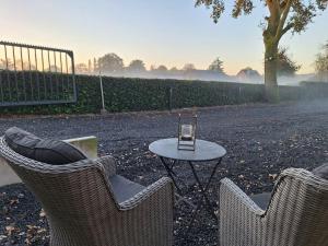 two chairs and a table with a glass on it at Het Uitzicht in Malden