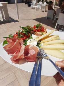 a plate of food with meat and vegetables on a table at Residence Parco del Sole in Rodi Garganico