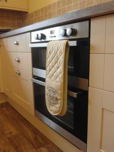 a kitchen oven with a towel hanging from it at Peers Clough Farm Cottage in Rossendale