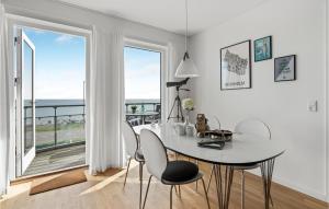 a white dining room with a table and chairs and a balcony at Awesome Apartment In Allinge With Wifi in Allinge