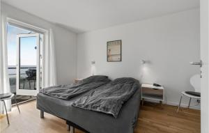 a bedroom with a bed and a large window at Awesome Apartment In Allinge With Wifi in Allinge +12 photos
