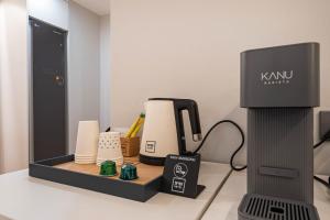 釜山にあるNo 25 Hotelの鏡の横のカウンターに掛けられた久喜コーヒーメーカー +20枚の写真