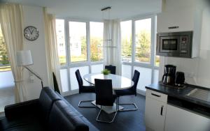 a kitchen and living room with a table and a couch at Leuchtturm 7 in Grossenbrode