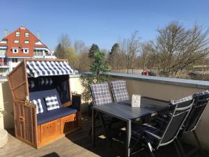 a balcony with a table and chairs on a roof at Leuchtturm 7 in Grossenbrode