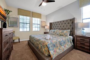 a bedroom with a bed and a dresser and windows at Embrace Disney Magic at Our Luxe 6-BR Villa in ChampionsGate! in Davenport