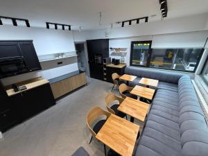 a room with a couch and tables and a tv at JADE - guesthouse in Buzău