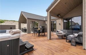 eine Terrasse mit einem Sofa und Stühlen auf einer Holzterrasse in der Unterkunft Amazing Home In Hvide Sande With Sauna in Bjerregård + 28 Fotos