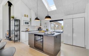 eine Küche mit weißen Schränken und einer großen Insel in der Unterkunft Amazing Home In Hvide Sande With Sauna in Bjerregård