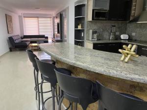 ポルラマルにあるApartamento Vacacional - Vista al Mar - Petalo 4 Piso 1のキッチン(椅子付きのバー付)