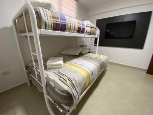 ポルラマルにあるApartamento Vacacional - Vista al Mar - Petalo 4 Piso 1のテレビ付きの客室で、二段ベッド1台が備わります。