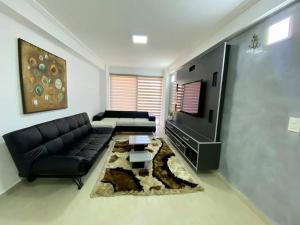 ポルラマルにあるApartamento Vacacional - Vista al Mar - Petalo 4 Piso 1のリビングルーム(黒いソファ、テレビ付)