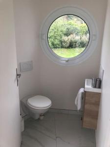 a bathroom with a toilet and a round window at Port Saint Jean - Maison de Designer in Saint-Jean-le-Thomas
