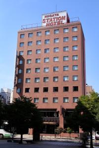 a large brick building with a sign on it at Niigata Station Hotel in Niigata
