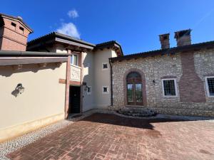 a house with a brick driveway in front of a building at Locazione turistica Casa Delle Ceramiche in Brendola