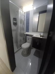a bathroom with a toilet and a sink and a mirror at Apartaestudios amoblados el caney in Cali