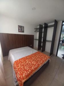 a bedroom with a bed with a brown blanket on it at Apartaestudios amoblados el caney in Cali