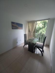 a dining room with a table and chairs and a window at Apartaestudios amoblados el caney in Cali