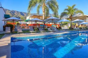 a swimming pool with chairs and umbrellas at Hotel del Pescador in Ajijic