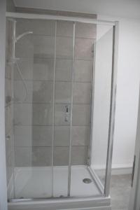 a shower with a glass door in a bathroom at No 13 Colchester Town Flat with Kitchen & Parking in Colchester