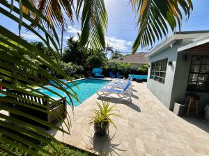 フォート・ローダーデールにあるPOOLSIDE MANOR - Men Only Clothing-Optionalのラウンジチェア2脚付きのスイミングプールが隣接しています。