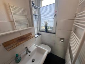 a small bathroom with a sink and a toilet at Ferienwohnung NORDLICHT mit Balkon und Smart-TV in Rostock +8 photos