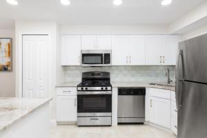 a white kitchen with a stove and a microwave at Westgate Leisure Resort in Orlando
