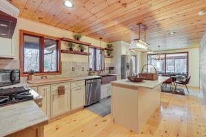 a large kitchen with wooden ceilings and a wooden floor at Ski, Hike and More Spacious Log Cabin in Long Pond in Long Pond