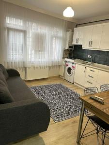 Una sala de estar con un sofá y una cocina. en Üsküdar - Venüs home - Sakin Konaklama, en Estambul