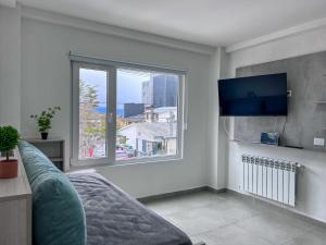 a living room with a couch and a large window at Goleta Florencia 2045 in Ushuaia