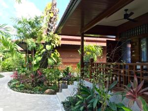 a garden in front of a house with many plants at Smile House - Fisherman Village in Bophut