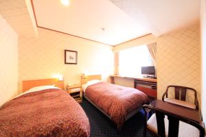 a hotel room with two beds and a window at Niigata Station Hotel in Niigata