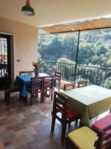 una sala da pranzo con tavolo e sedie e una grande finestra di Dream Valley حلم الوادي a Sirjbāl