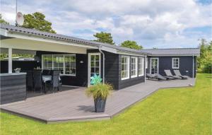 a deck with chairs and a table on a house at Holiday Home Hadsund 09 in Nørre Hurup