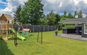 a yard with a playground with a slide at Holiday Home Hadsund 09 in Nørre Hurup