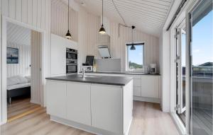 a kitchen with white cabinets and a counter top at Lovely Home In Ebeltoft With Sauna in Ebeltoft
