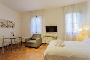 a bedroom with a bed and a table and a chair at Yourbanflat Il Chiostro Nascosto in Padova