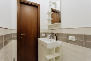 a bathroom with a sink and a wooden door at Yourbanflat Il Chiostro Nascosto in Padova +15 photos