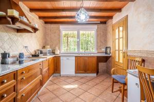 a large kitchen with wooden cabinets and a window at Senderos de la Alhambra in La Zubia