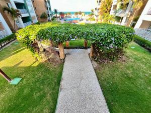 a park bench with a bush in a yard at Terramaris - Paraíso Pé na areia in Aquiraz