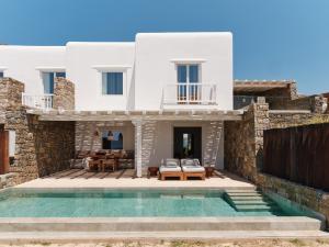 a villa with a swimming pool and a house at The Coast Bill&Coo-The Leading Hotels of the World in Agios Ioannis Mykonos