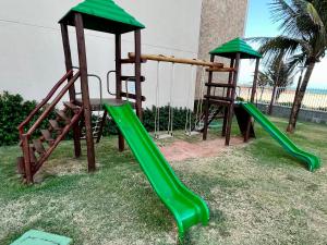 a playground with two swings and a slide at Terramaris - Paraíso Pé na areia in Aquiraz